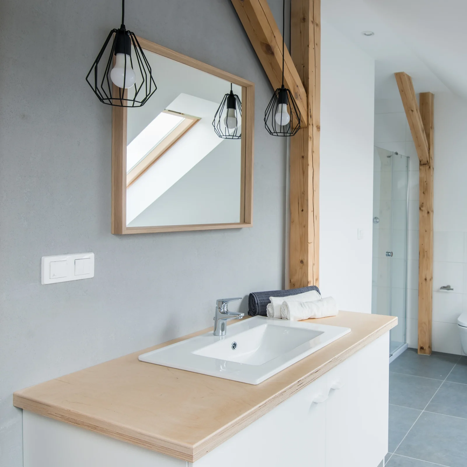 Modern loft bathroom interior with wooden beams and natural light