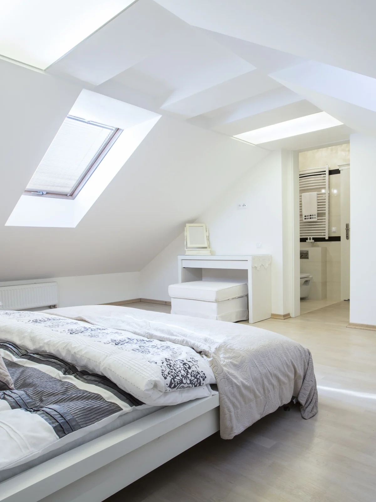 Spacious loft bedroom conversion by Renavo Build with en-suite bathroom