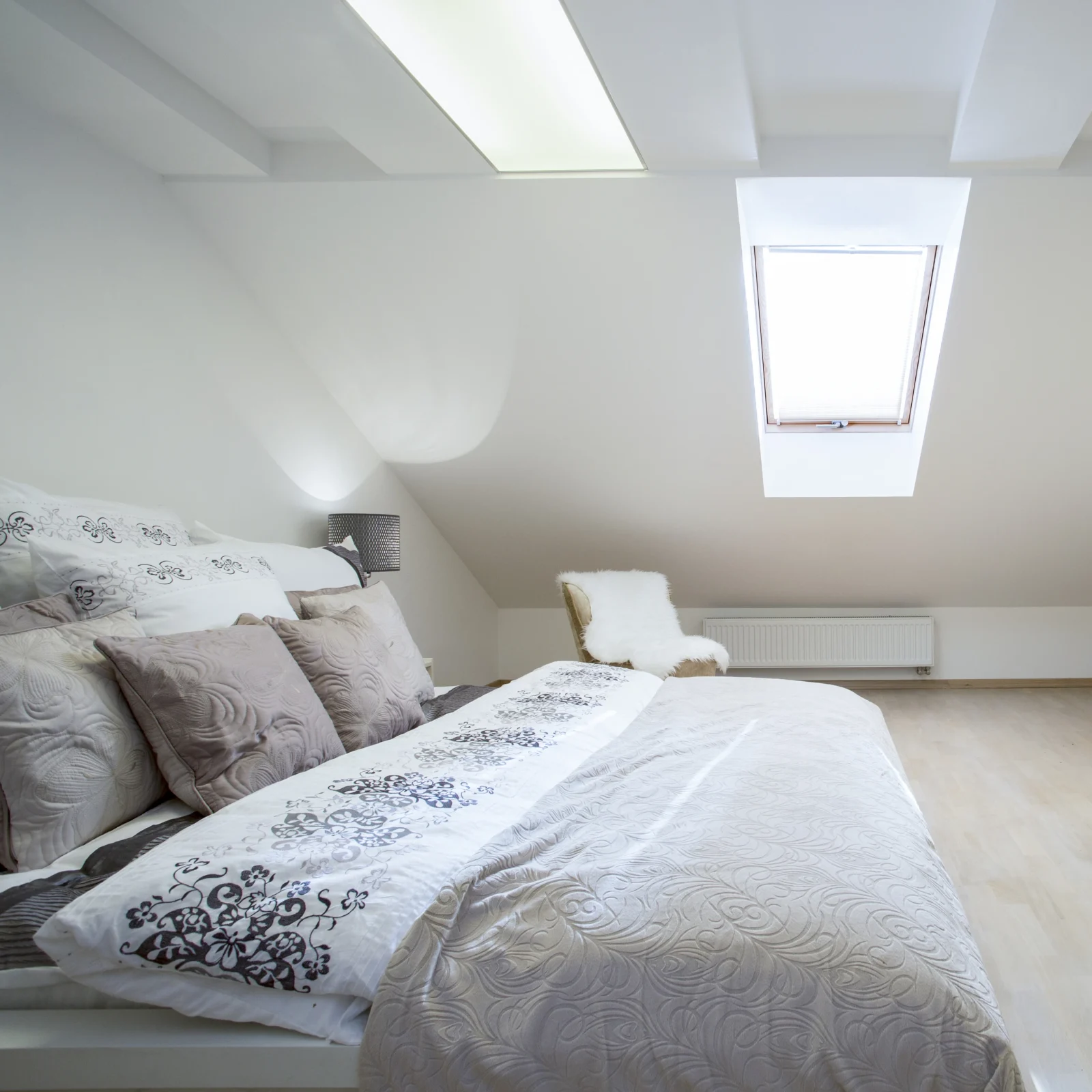 Minimalist loft bedroom design with sloped ceiling and skylight