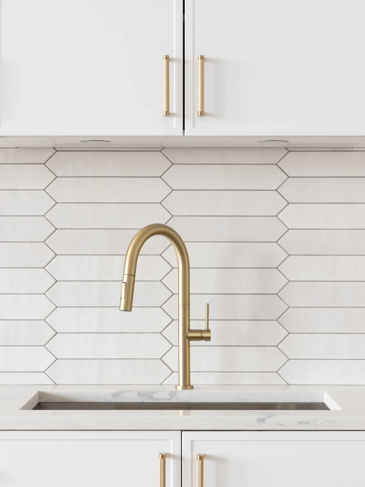 Minimalist kitchen interior with white cabinetry and gold fixtures