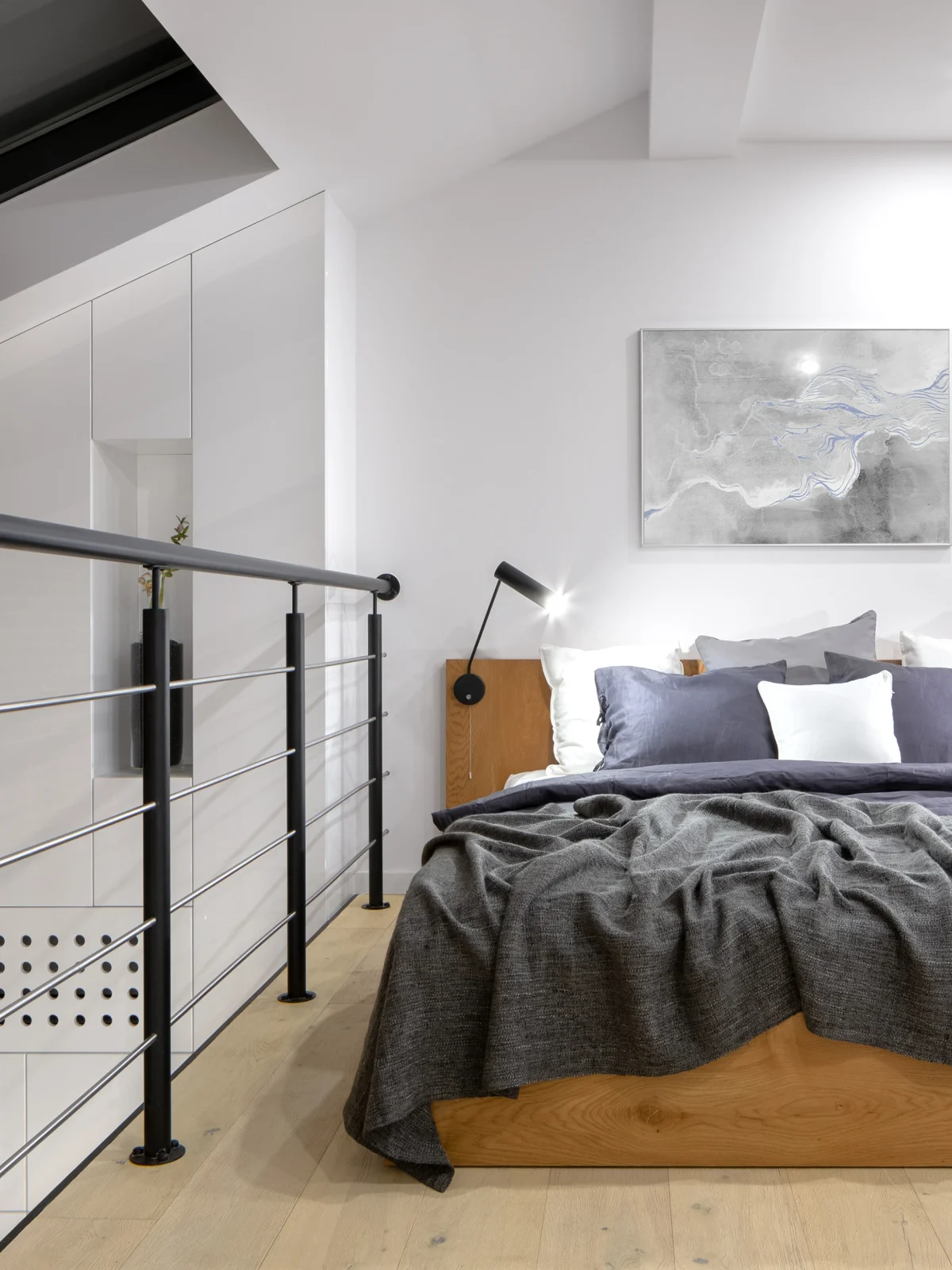 Minimalist loft bedroom with modern lighting and wooden accents by Renavo Build