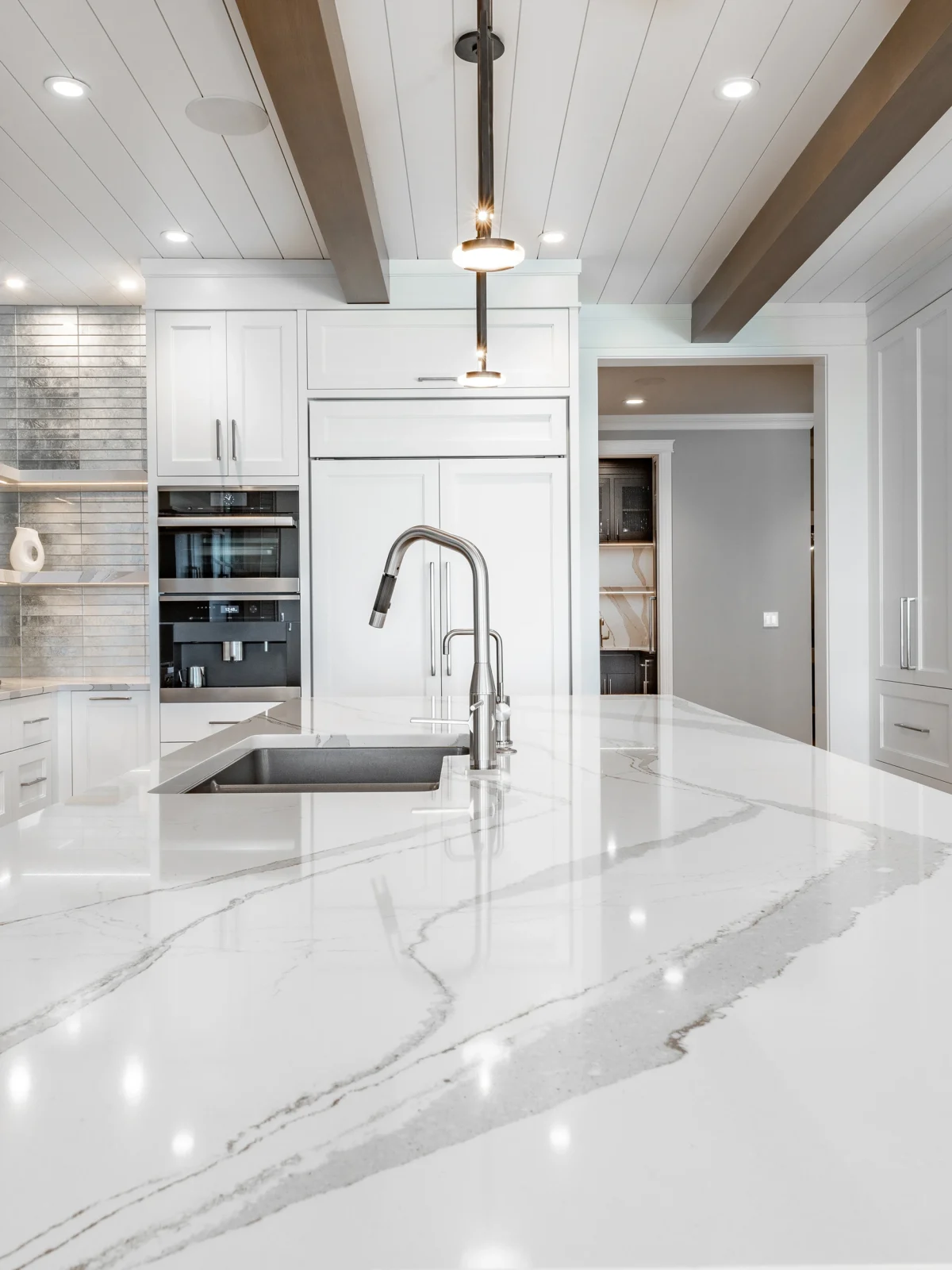 Modern white kitchen with marble island and sleek cabinetry design